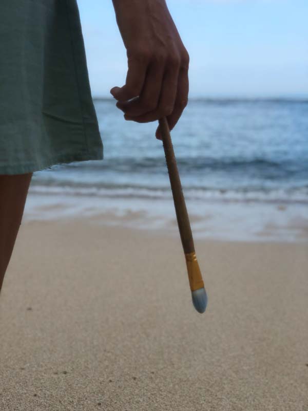 Hand Holding Paint Brush At Beach